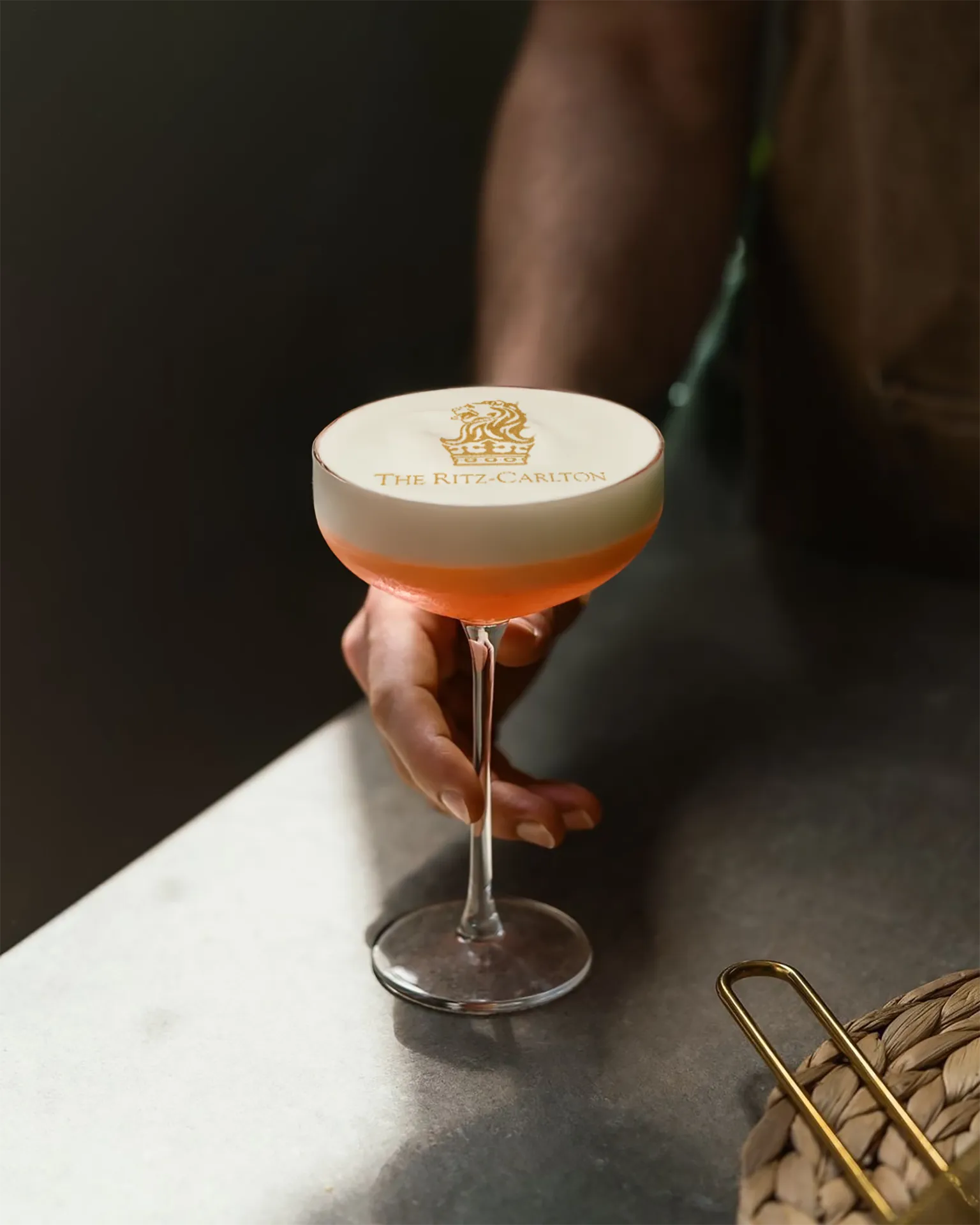 Cocktail printer result: The Ritz-Carlton logo on foam of a cocktail held at a bar