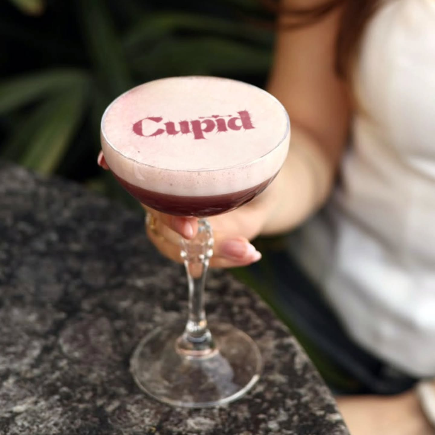 طابعة موكتيل: كلمة 'Cupid' على رغوة الموكتيل ممسوكة بيد