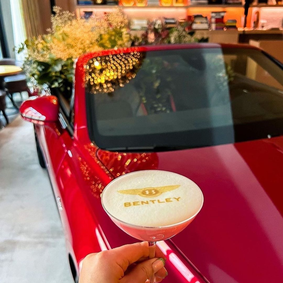 Cocktail-Drucker Ergebnis: Bentley-Logo auf dem Schaum eines Cocktails mit rotem Auto im Hintergrund