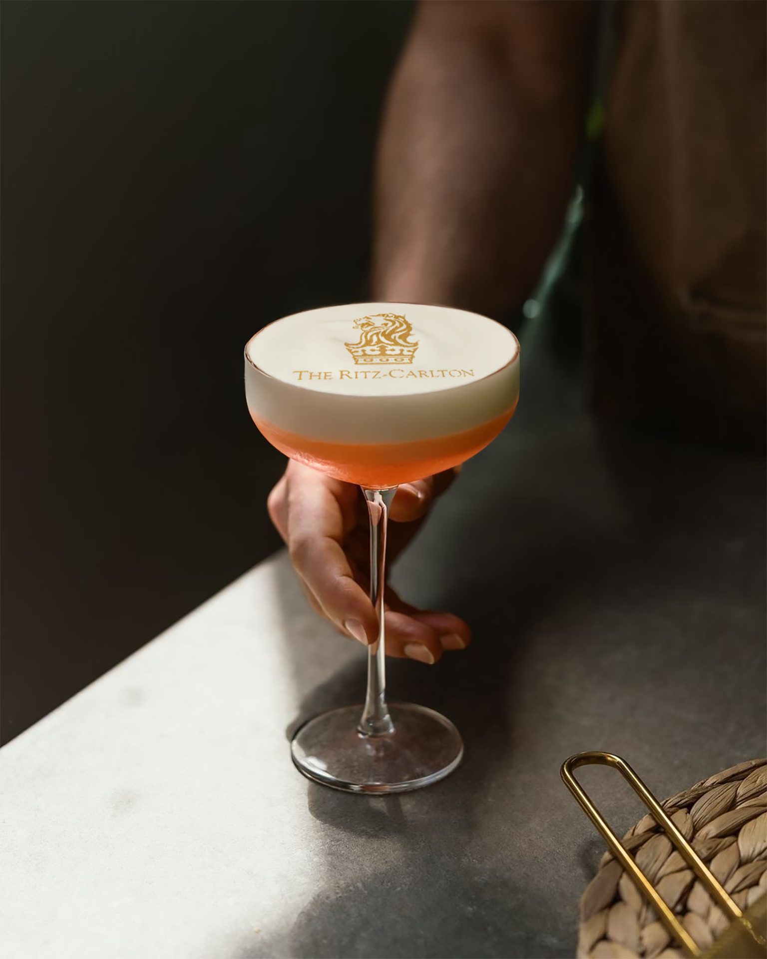Cocktail-Drucker mit The Ritz-Carlton Logo im Schaum eines Cocktails, von Hand gehalten