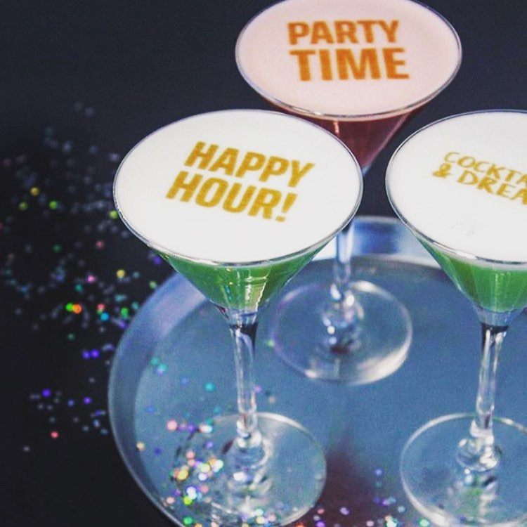 Impressora de drinks com textos em três coquetéis em uma festa