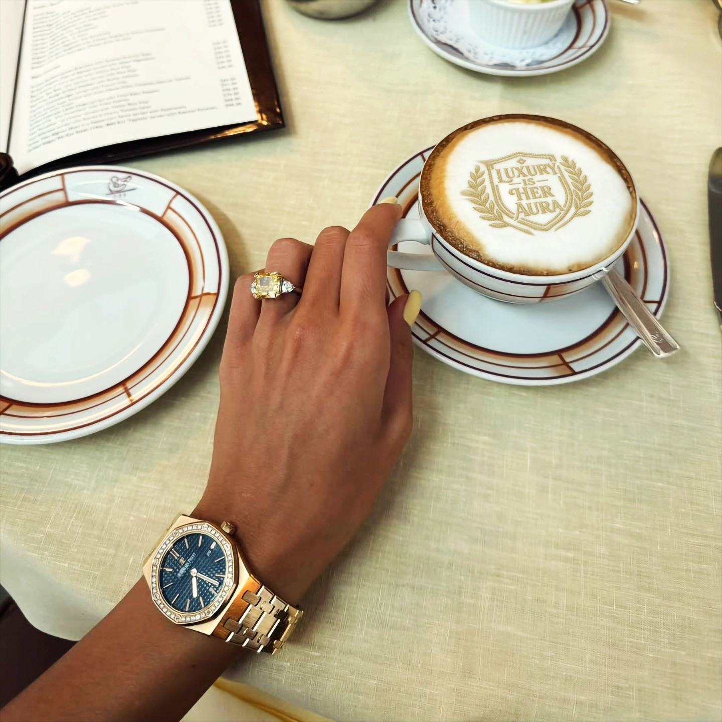 Imprimantă latte art cu textul 'Luxury is Her Aura' pe cafea la o masă de cafenea stilată