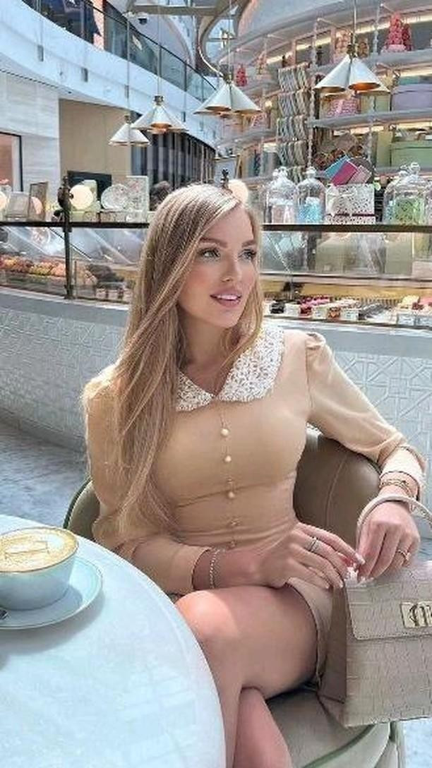 Latte art printer design on coffee at café table with woman