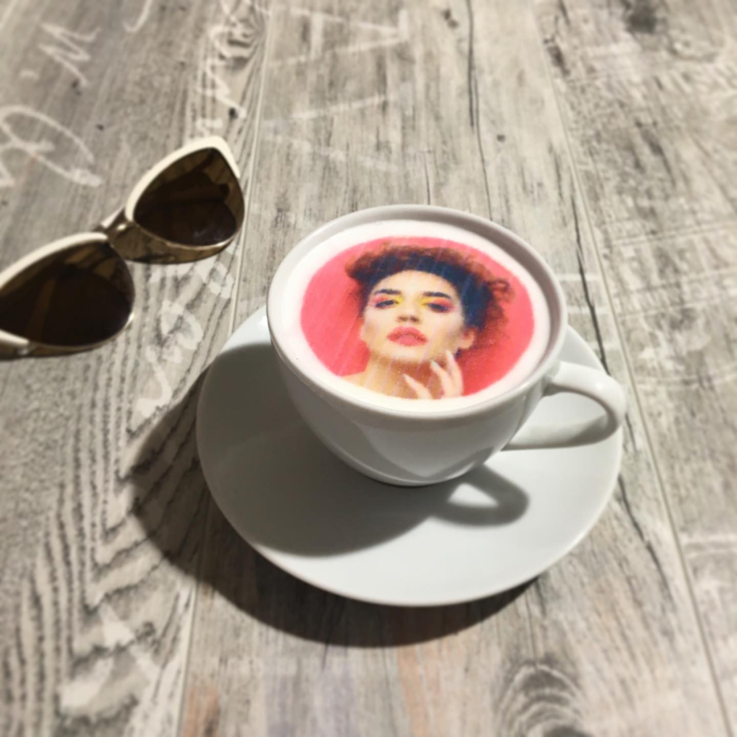 Milchschaumdrucker-Ergebnis: Porträt auf Latte-Schaum neben Sonnenbrille