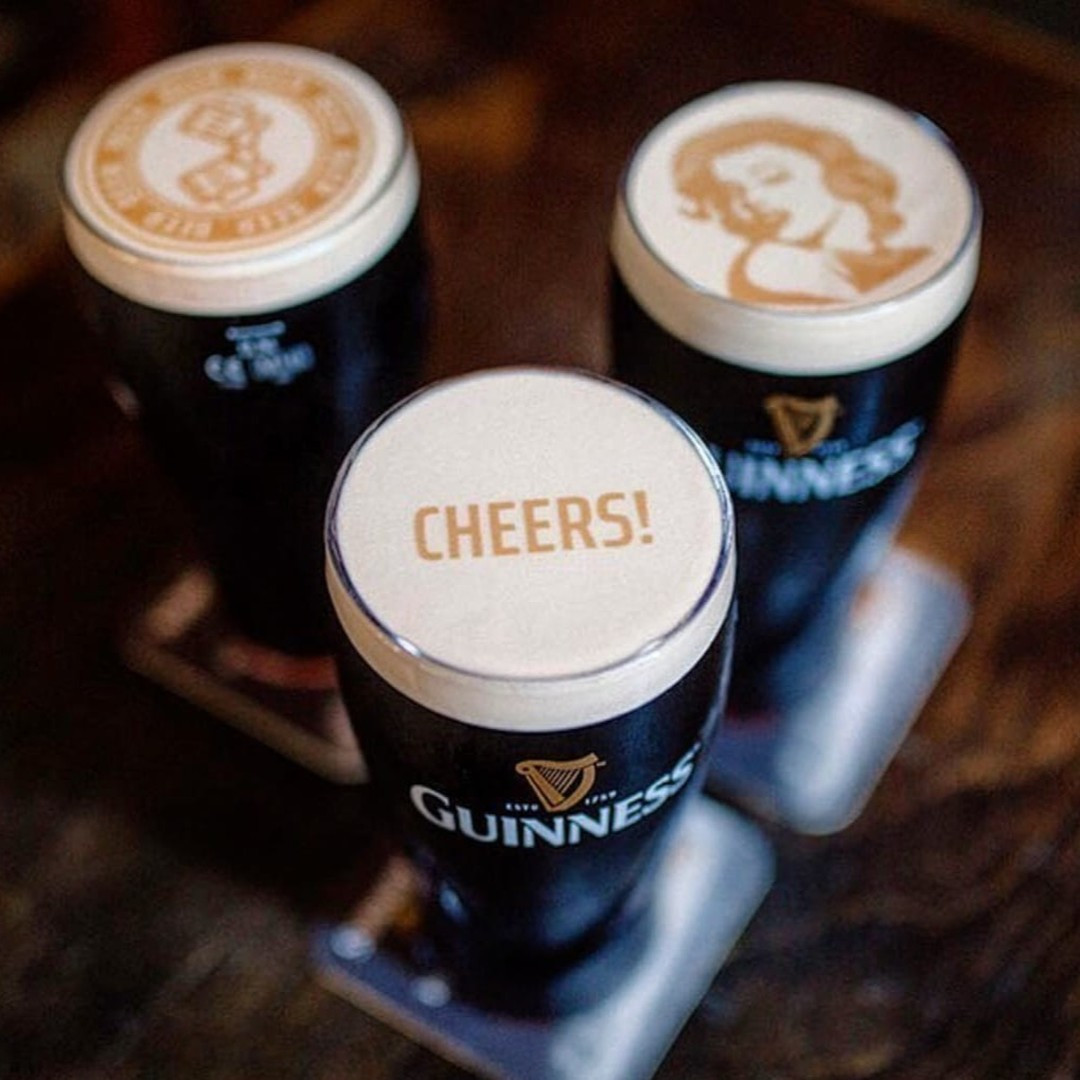 Τρία ποτήρια Guinness με λογότυπο 'CHEERS!' στον αφρό σε φεστιβάλ μπύρας